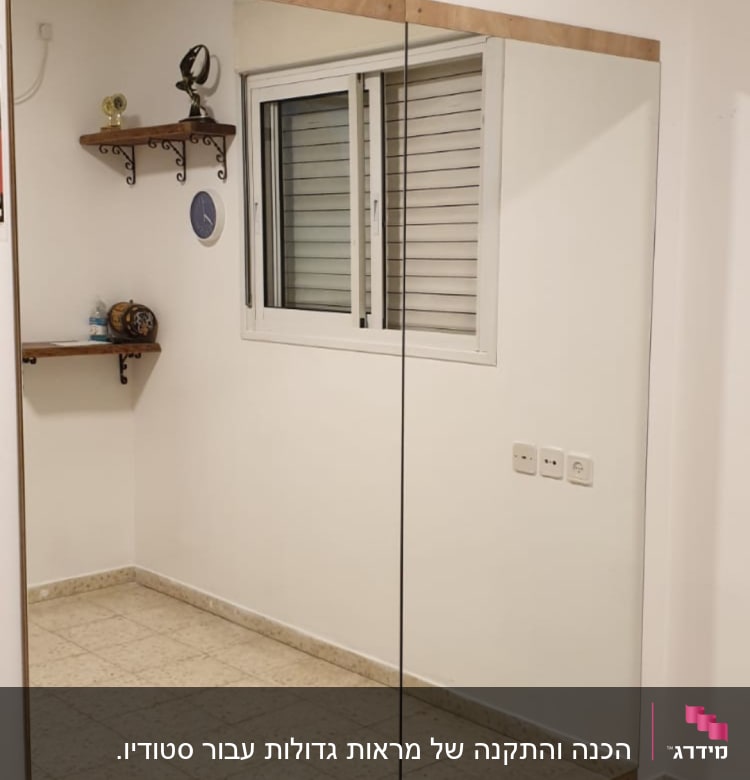 מראה גדולה עם מסגרת עץ על קיר לבן